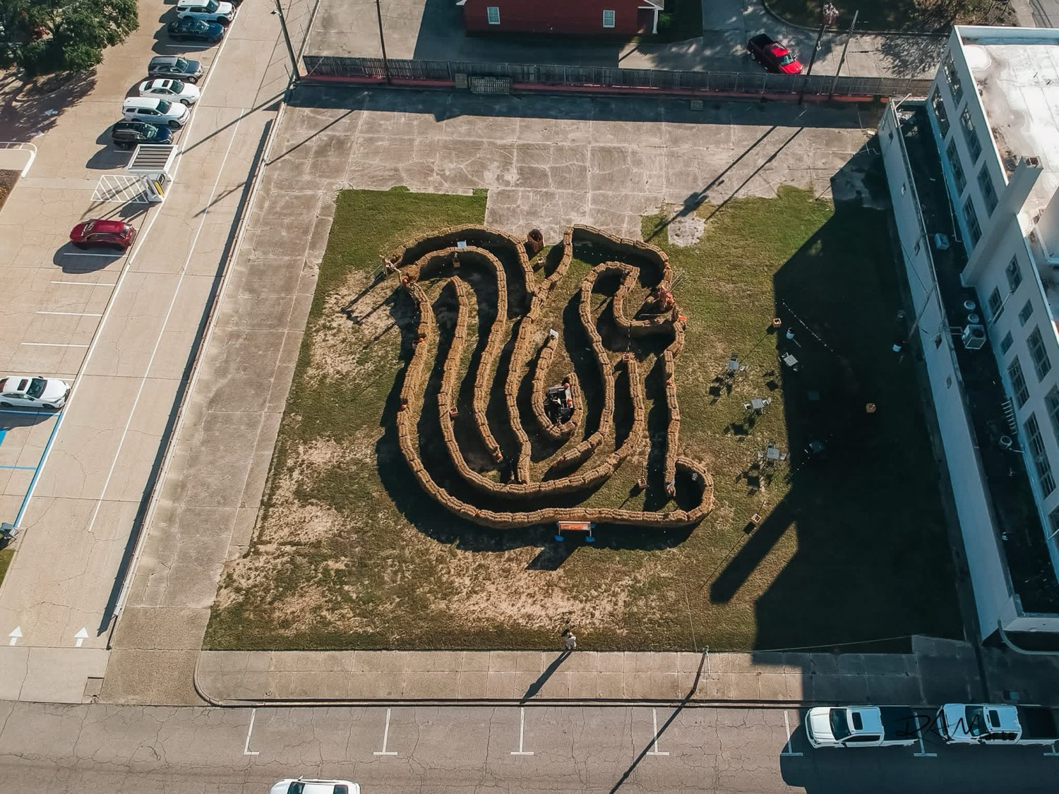 Aerial view of a winding hay-bale maze filling a downtown lot in Columbia