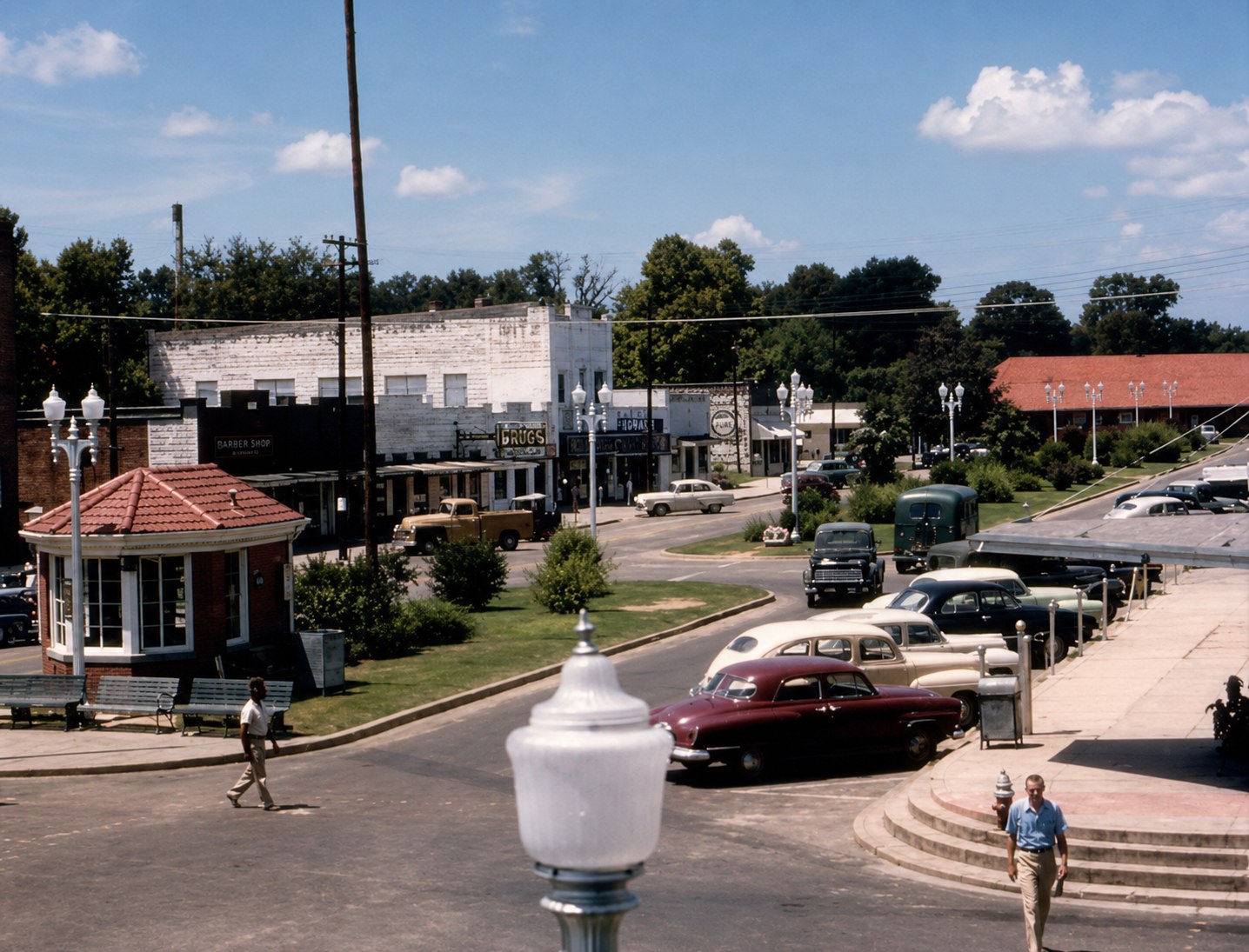 Colour photograph of downtown Columbia in the 1950s — the tile-roofed corner kiosk, a barber shop, a drug store and a Pure filling station, with midcentury cars angle-parked along Main. Photograph courtesy of the Marion County Historical Society.