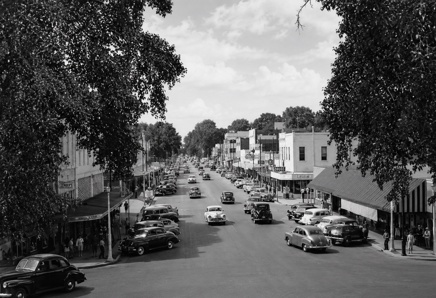 Main Street, Columbia, in the 1950s — Zender's and a drug store, both sides of the street angle-parked full, pedestrians on both sidewalks. Photograph courtesy of the Marion County Historical Society.