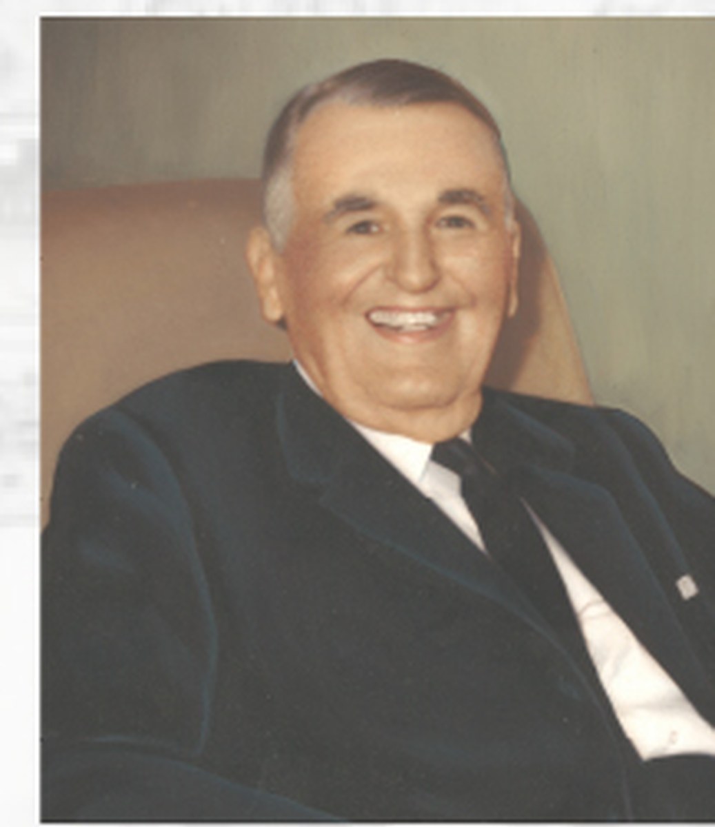 Governor Hugh Lawson White seated in a chair, smiling, in a dark suit and tie