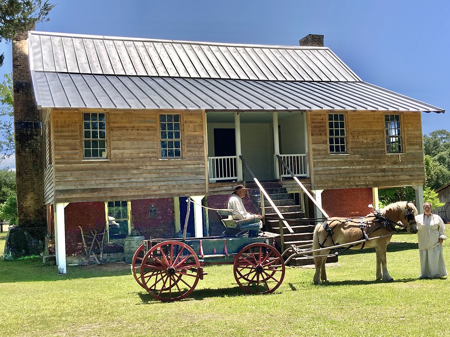 The John Ford Home, a two-story frontier house with a covered porch, with a horse and carriage on the lawn