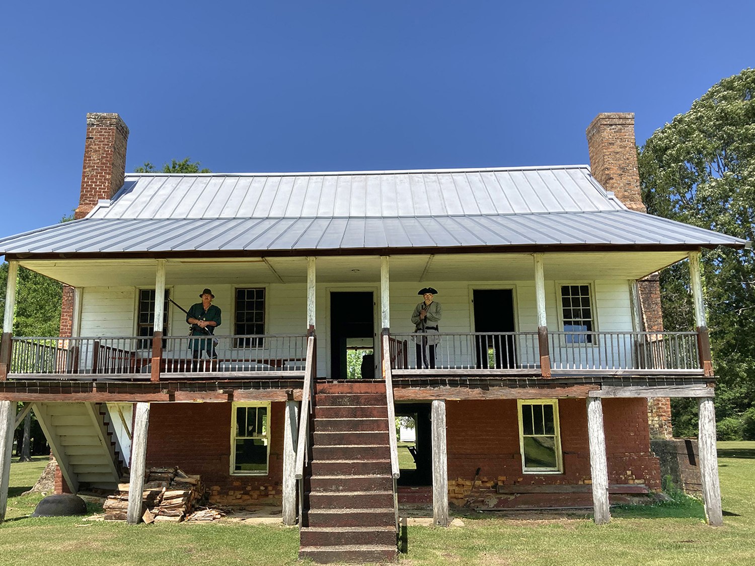 The front elevation of the John Ford Home with interpreters in period dress on the upper porch