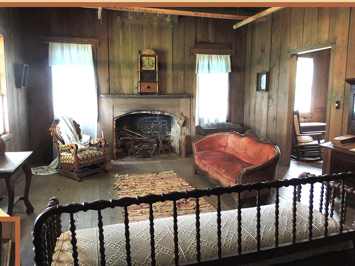 A second-floor room with a fireplace, settee and rocking chair