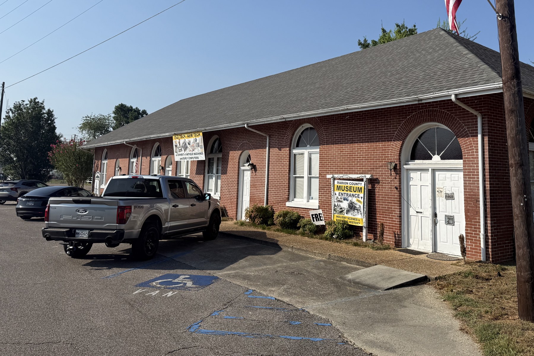 The Marion County Museum on Second Street in Columbia, a low brick building with arched windows and an American flag by the entrance