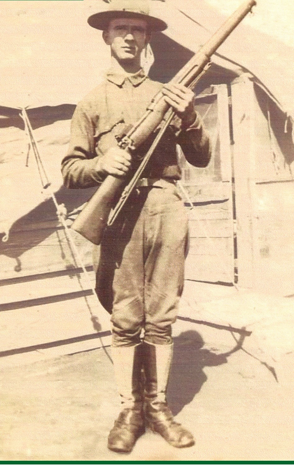 Private Horatio Weston Rankin in uniform, holding his rifle, photographed at an army camp before shipping out